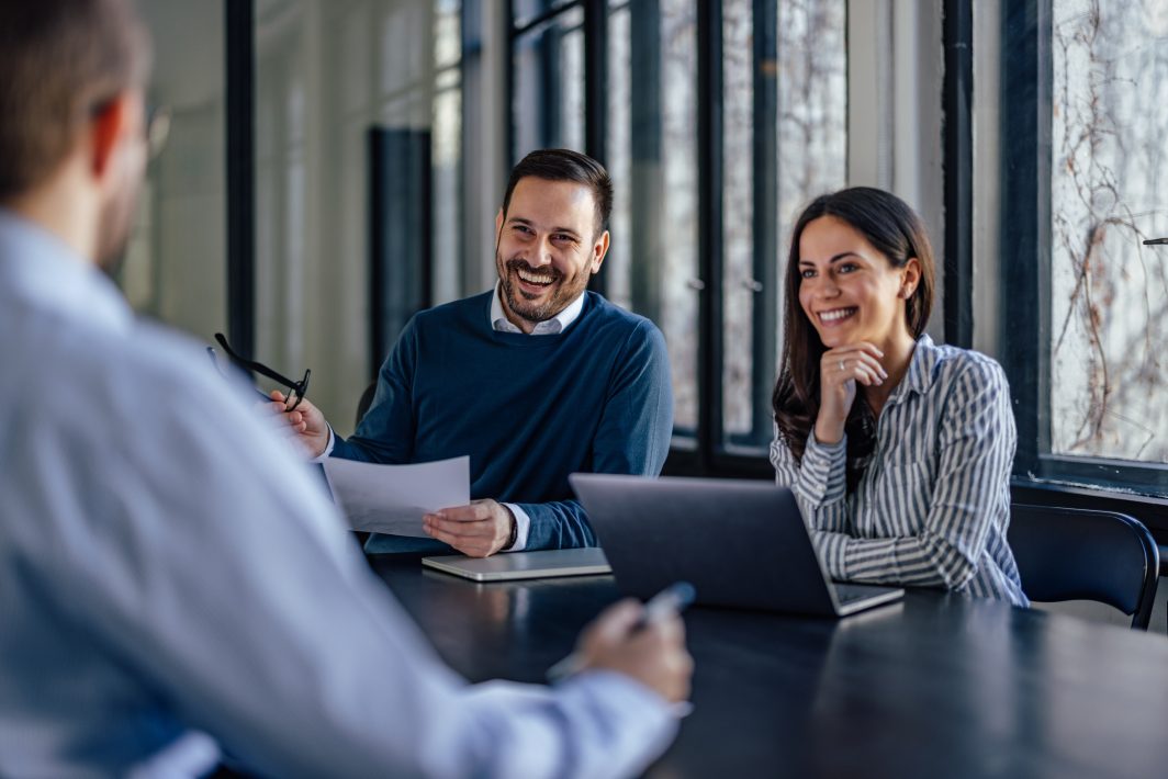 A couple in a meeting room discussing their property investment strategy with a real estate expert in Perth Australia.